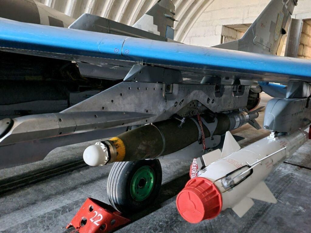 ウクライナ空軍のミコヤン MiG-29「フルクラム」多目的ジェット機のクローズアップ写真。JDAM 爆弾と R-73 短距離空対空ミサイルを装備しています。 飛行機は格納庫内に駐機されています。