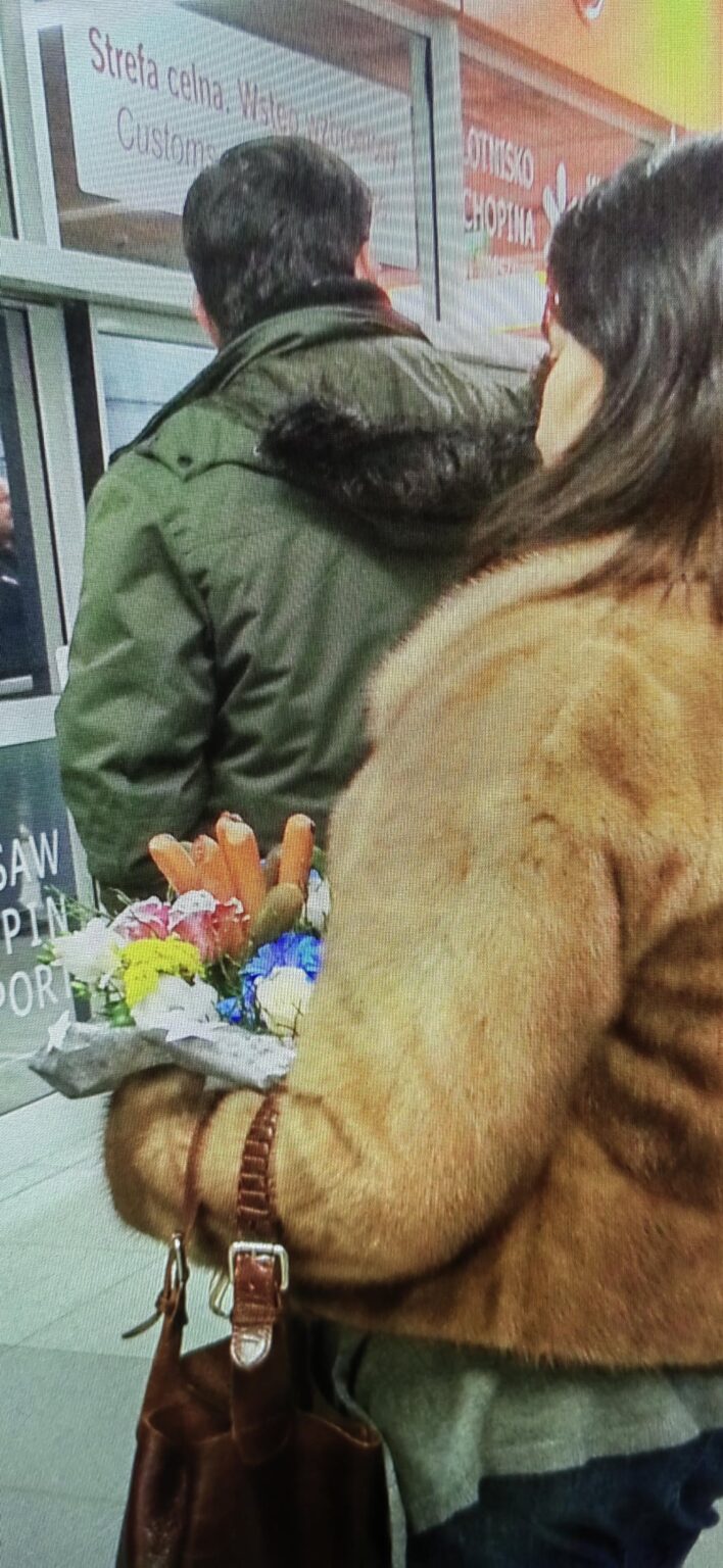 一体ポーランドとは何だ？ ワルシャワのショパン空港。 この女性は花束とソーセージとピクルスを持って誰かを待っている!? 自分自身を説明してください！