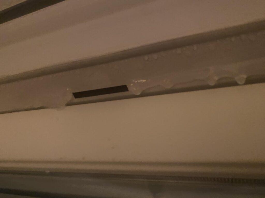 窓の換気口が結露と凍結を示しています… 🙄