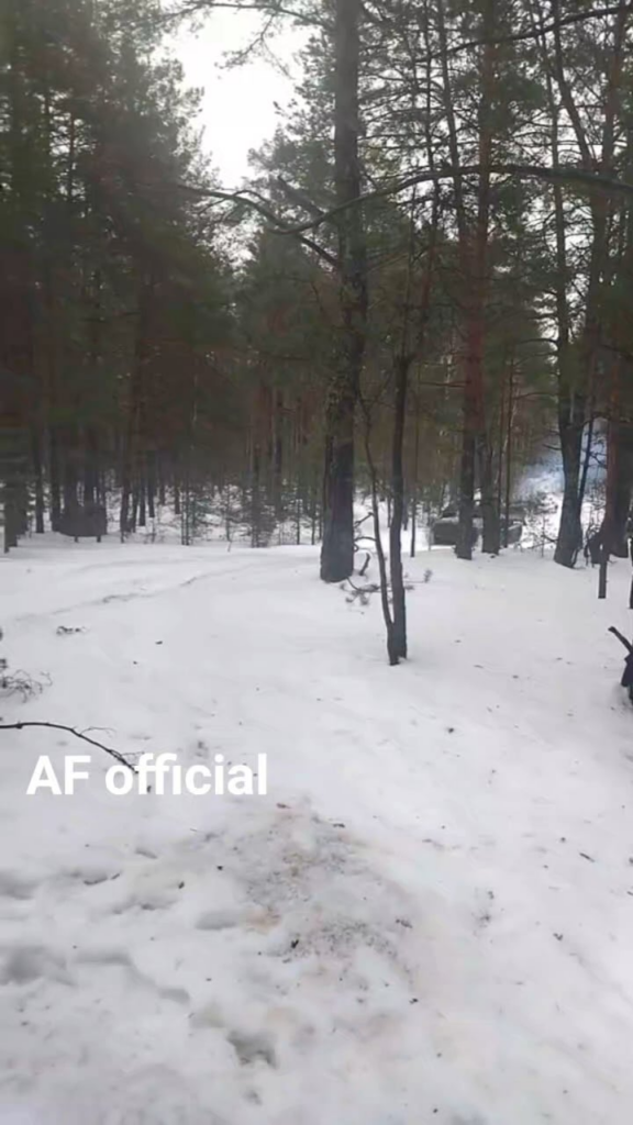 雪上迷彩を着たウクライナ軍兵士がMT-LB APCに乗って森の中を進む。