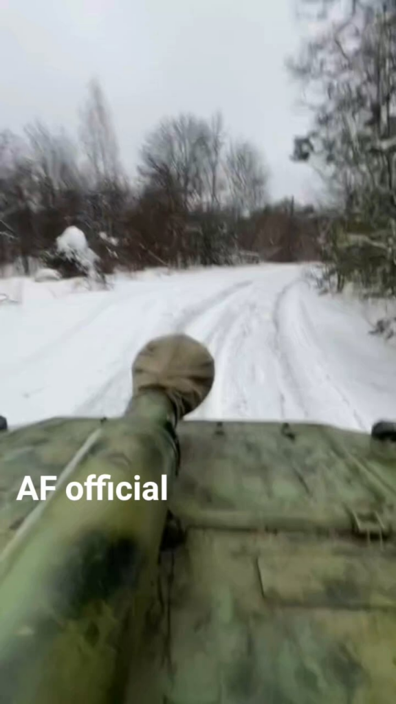 ウクライナの砲兵が 2S1 グヴォズディカ 122mm 自走榴弾砲に乗り、雪に覆われた森林地帯を駆け抜けます。