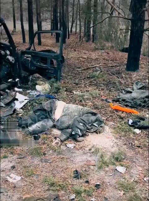 破壊されたラーダ・ニーヴァの隣でKIAロシア車を撮影するウクライナ兵士。