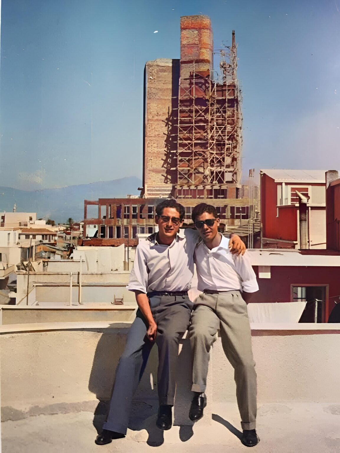 古いニコシアの屋上にいる 2 人の友人と建設中のキプロス初の「超高層ビル」、1959 年