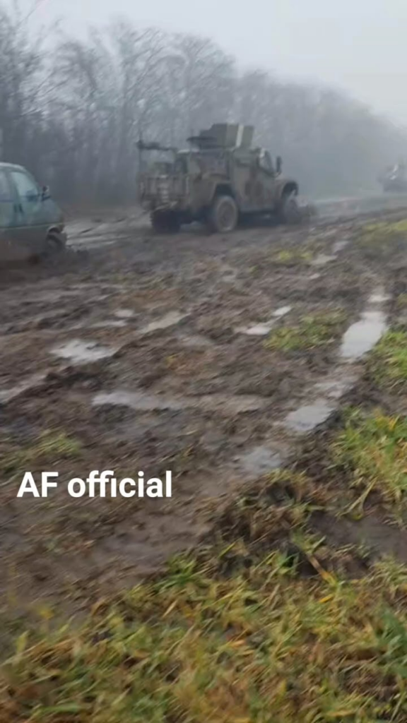 ウクライナの MRAP は、特に泥だらけの未舗装道路をミニバンを牽引して走行します。