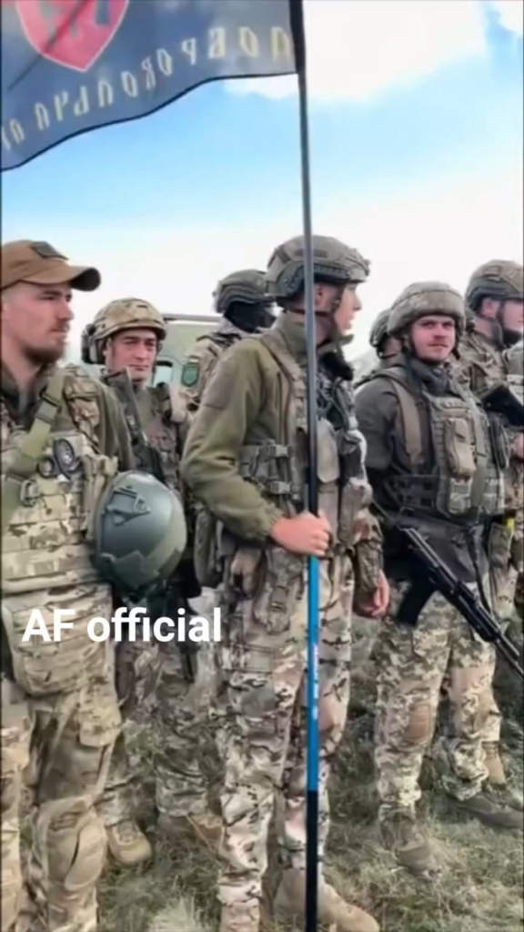 国旗を翻したウクライナ軍兵士とイギリス供給のスパルタンAPCの整列。