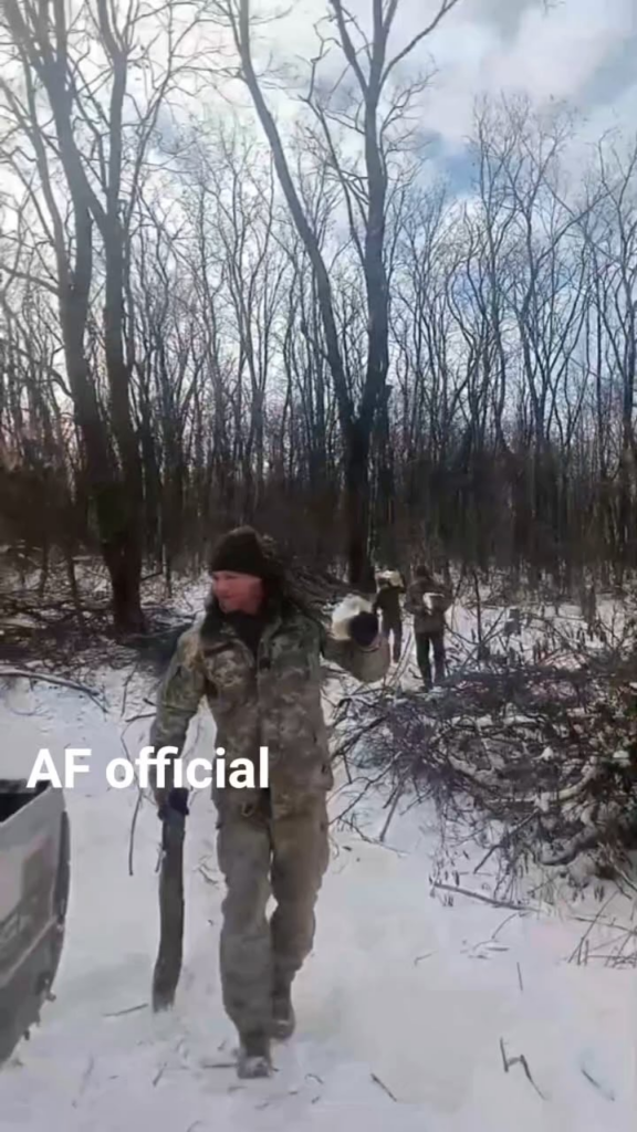 ウクライナの兵士たちは冬の暖かさを求めてピックアップトラックに薪を積み込んでいる。