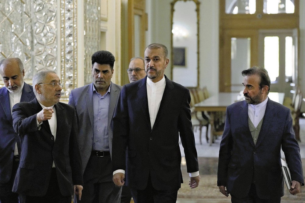 １４日、テヘランで、各国大使らとの会合に向かうイランのアブドラヒアン外相（中央）＝ＡＰ