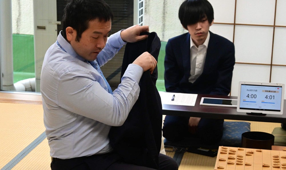 上着を脱ぐ丸山九段