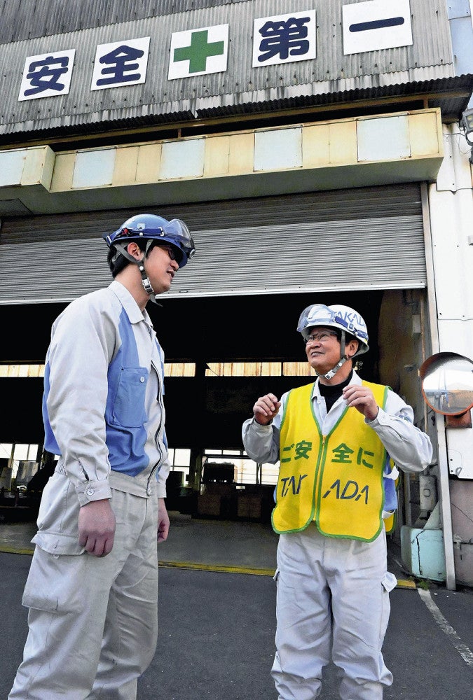定年退職の年齢引き上げを受けて働き続ける決断をした高田工業所の井口安全衛生室長（右）（３月２１日、北九州市で）