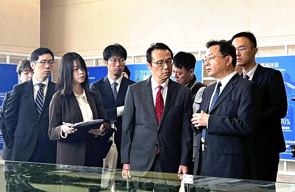 湖北省鄂州市で、孫兵・市共産党委員会書記（手前右）からの説明に耳を傾ける金杉憲治・駐中国大使（同中央）（３月２４日）＝田村美穂撮影