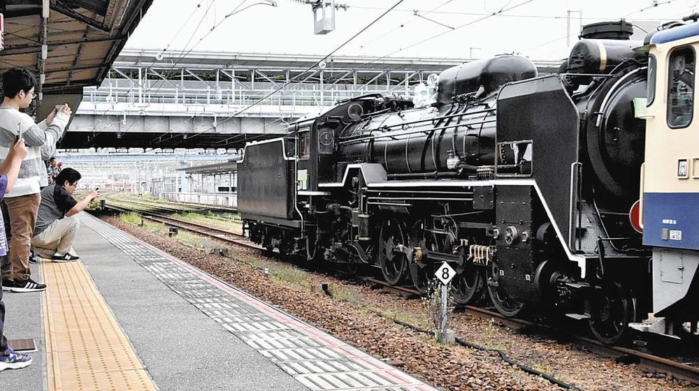 電気機関車に引かれてホームに入った黒い車体のＤ５１