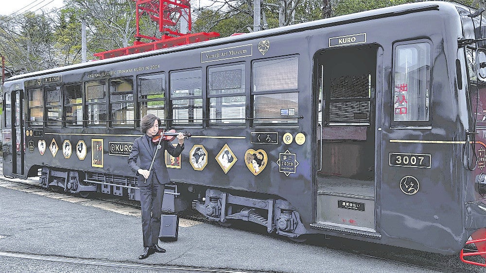 出発式に完成した車両の前で「宵待草」を演奏する大迫さん（岡山市中区で）