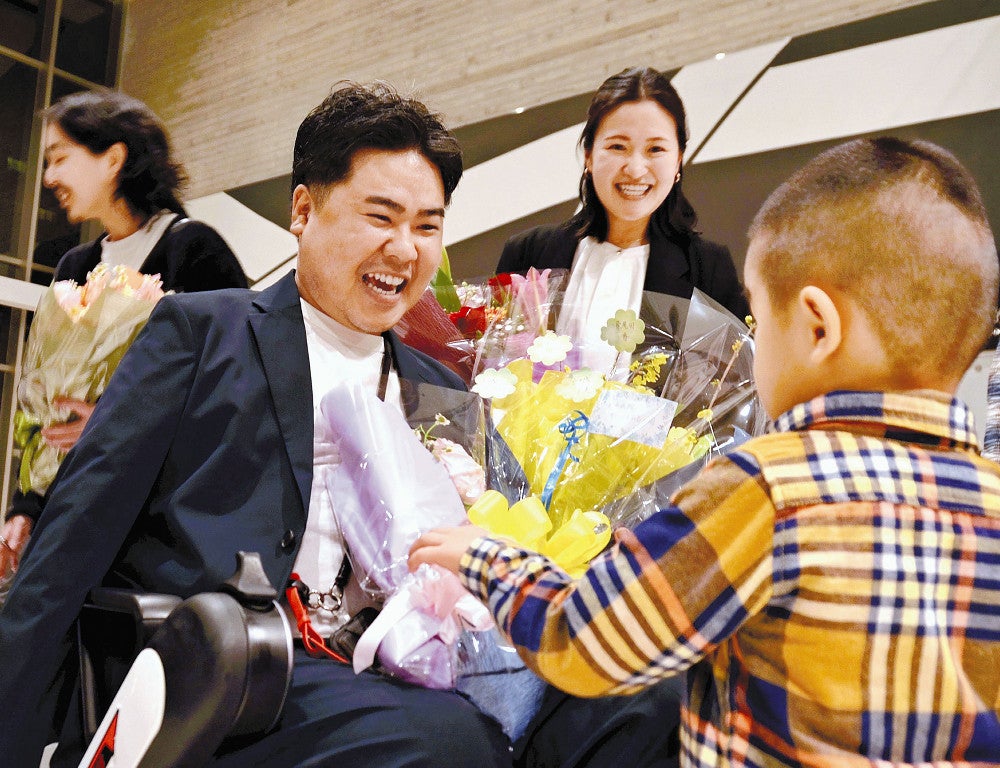訪問看護事業の起業を決意し、応援の花束を受け取って笑顔を見せる真栄田さん（中央左）と佐川さん（同右）（２月中旬、沖縄県糸満市で）