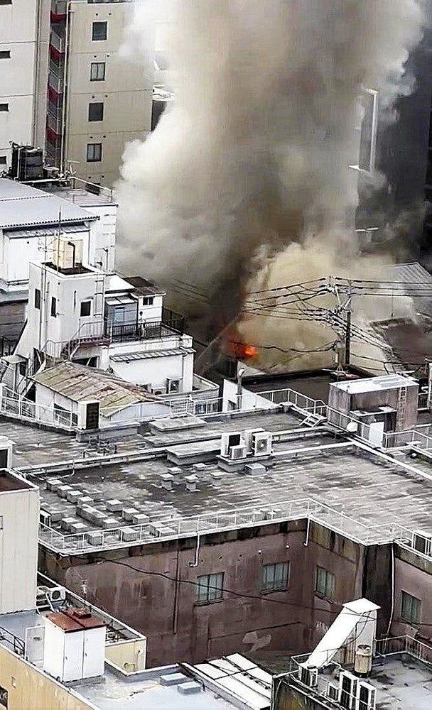 煙を上げて燃える建物（２０日午前、北九州市小倉北区で）＝住民提供
