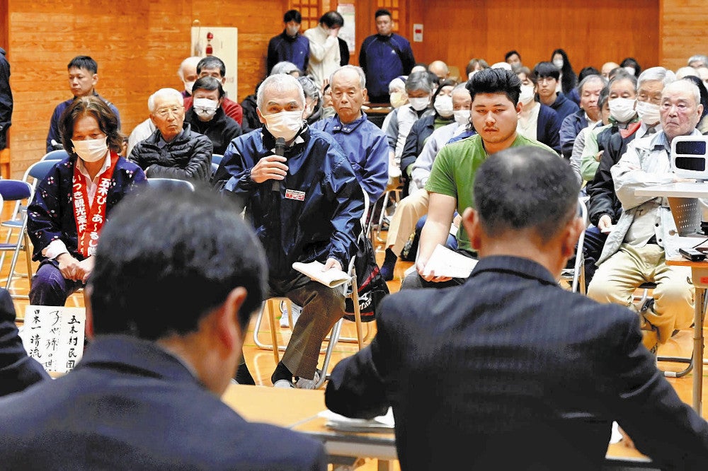 村民集会で意見を述べる参加者