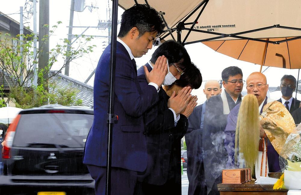 法要で手を合わせる、東京・池袋の事故で妻子を亡くした松永拓也さん（手前）（２３日午前、京都府亀岡市で）