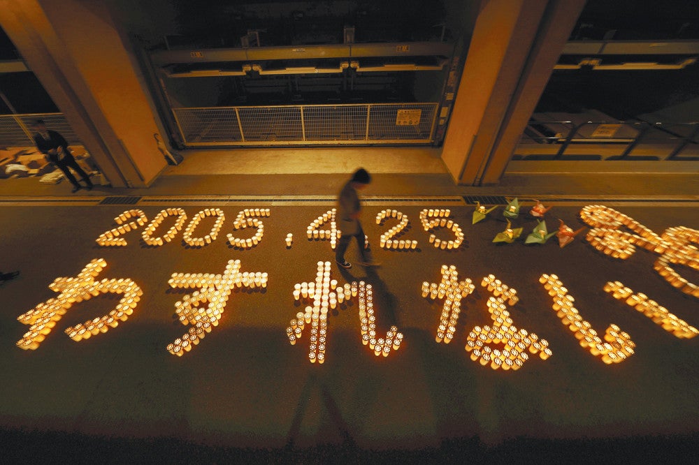 ろうそくの光で浮かびあがった「２００５・４・２５　わすれない」の文字（２４日夜、兵庫県尼崎市で）＝代表撮影