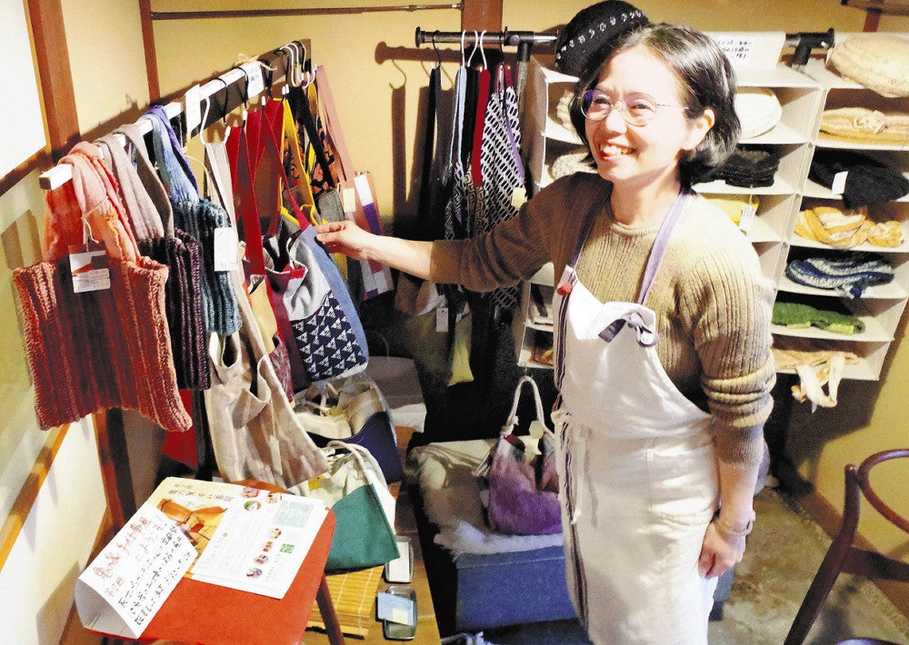 西村さんの手編み作品を店内に展示する中原さん
