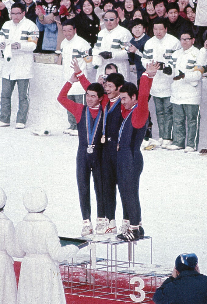 札幌五輪の表彰台で大観衆にこたえる（左から）金野昭次さん（左）、笠谷幸生さん（中）、青地清二さん（右）（１９７２年２月６日撮影）