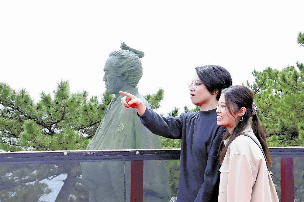 龍馬像と同じ目線で太平洋を眺める観光客（高知市で）