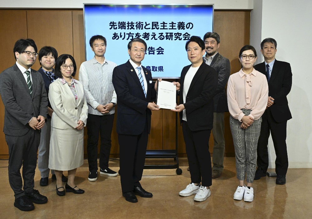 生成ＡＩに関する研究会の報告書を鳥取県の平井知事（中央左）に手渡す座長の山本龍彦・慶応大教授（同右）（２６日、東京都港区で）＝西孝高撮影