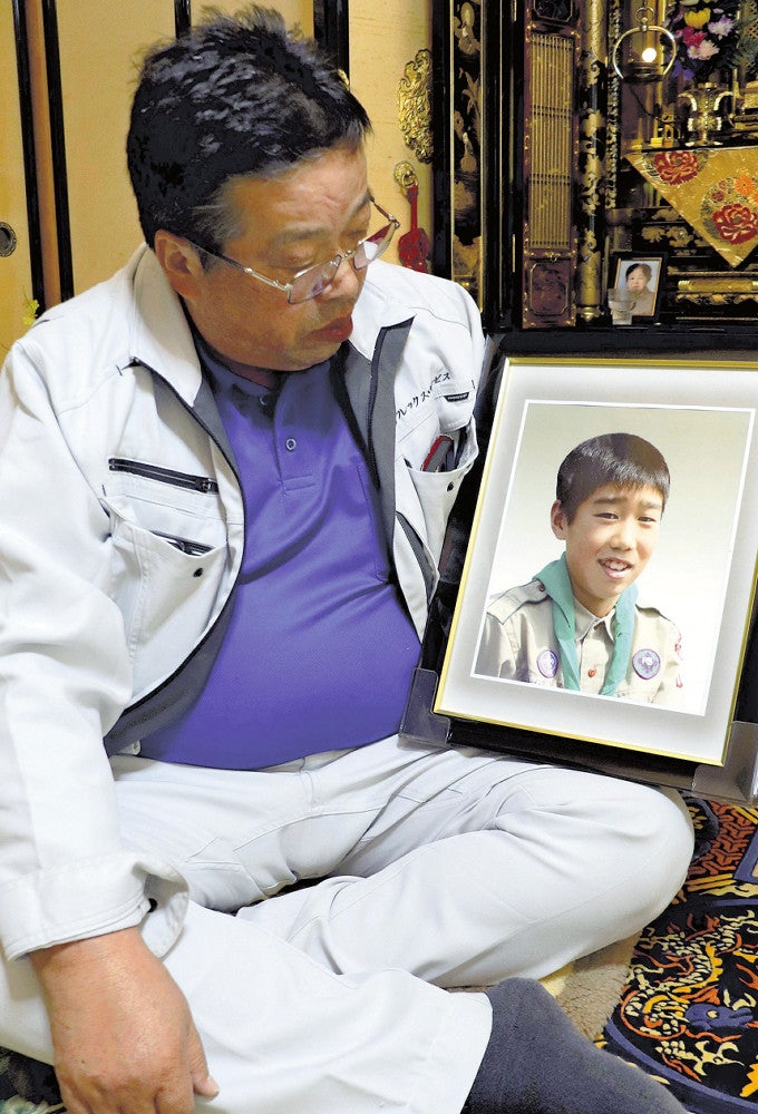 大貴君の遺影を抱える久保さん（１５日、小矢部市で）