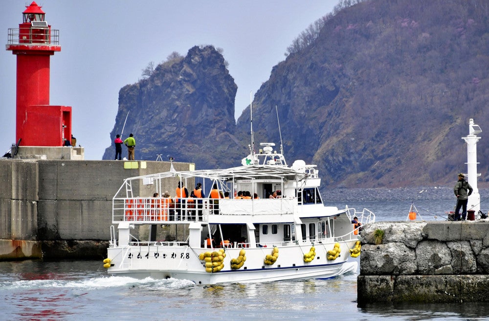 運航初日、ウトロ漁港を出航する小型観光船（２８日、北海道斜里町で）＝原中直樹撮影