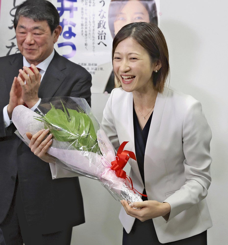 衆院東京１５区補選で当選確実となり、花束を手に笑顔の酒井菜摘さん（２８日午後８時１６分、東京都江東区で）＝須藤菜々子撮影