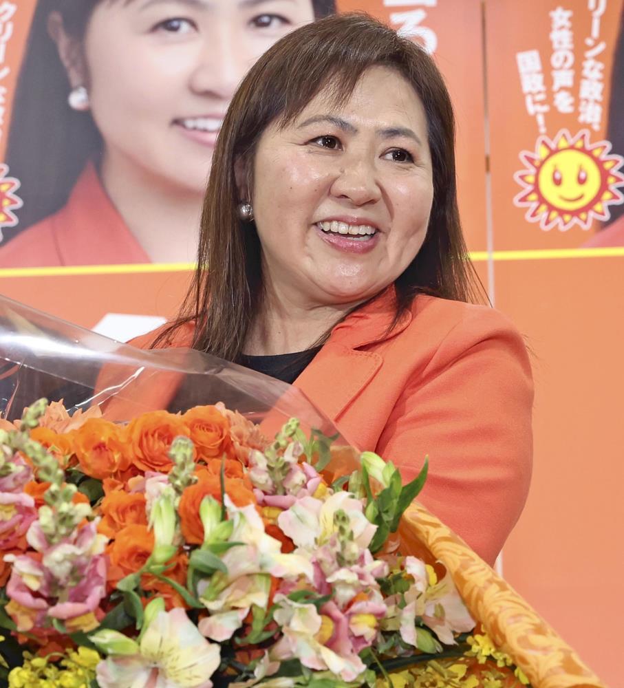 当選を確実にし、花束を手に笑顔を見せる亀井さん（２８日午後８時３分、松江市で）＝東直哉撮影