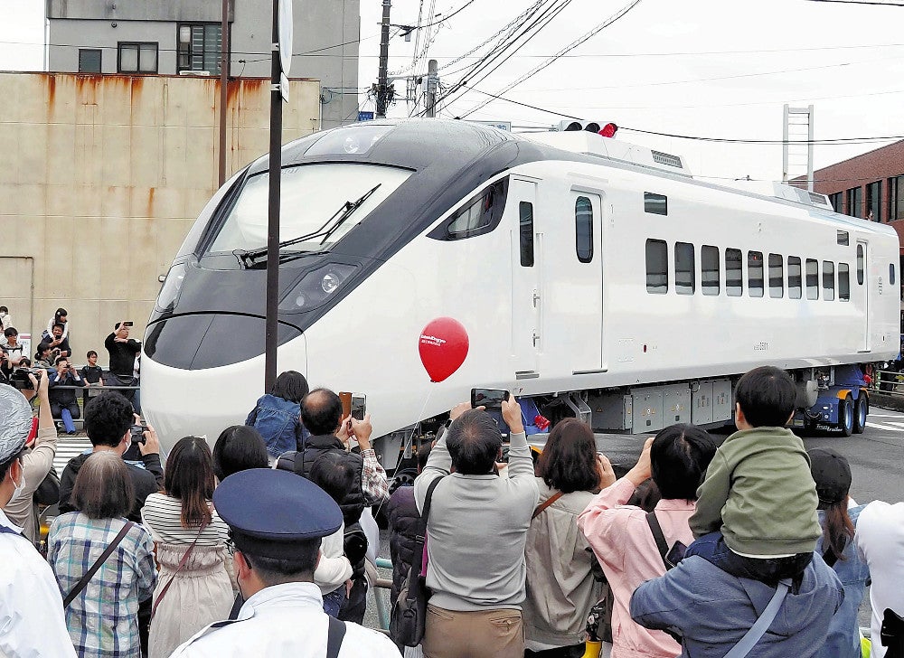 トレーラーで運ばれる特急車両。多くの見物客が詰めかけた