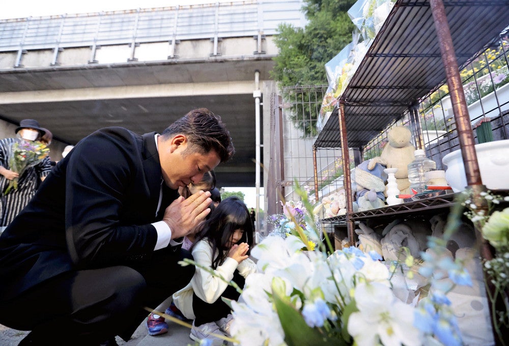関越道バス事故から１２年となり、現場近くの献花台で手を合わせる遺族ら（２９日午前４時４４分、群馬県藤岡市で）＝木田諒一朗撮影