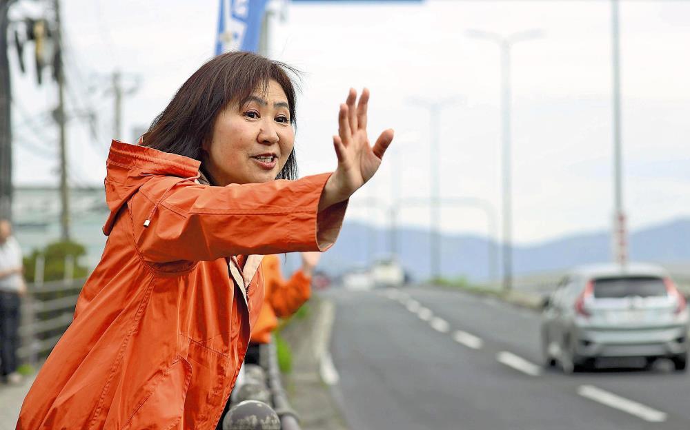 当選から一夜明け、街頭で手を振る亀井さん（２９日午前、松江市で）