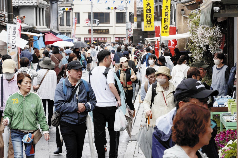 小雨が降る中、買い物客らでにぎわう歩行者天国