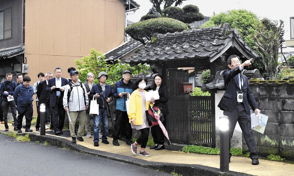 山内教授（右）の解説でまち歩きを楽しむ市民ら
