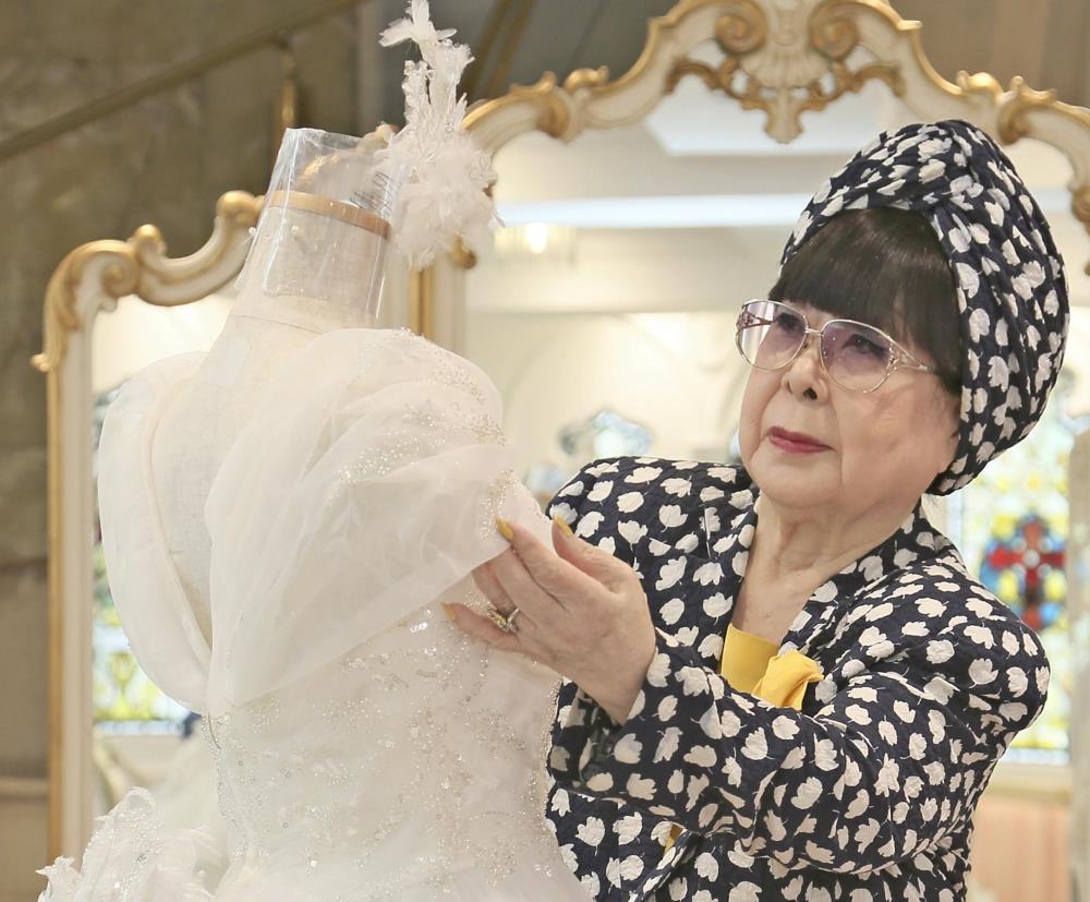 自身がデザインしたウェディングドレスを見つめる桂由美さん（２０２０年７月）＝鈴木竜三撮影