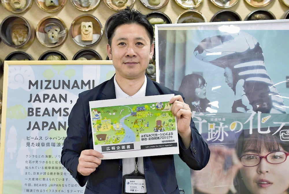 プロジェクトの企画書を手に喜ぶ伊藤さん（瑞浪市役所で）