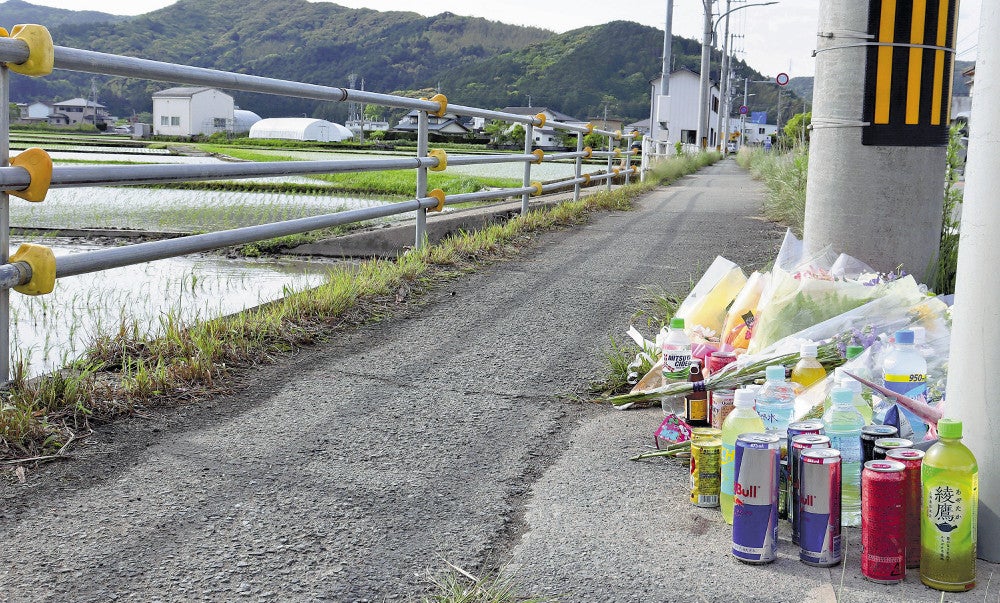 事故現場前の歩道に供えられた飲食物や花束（徳島県阿南市で）