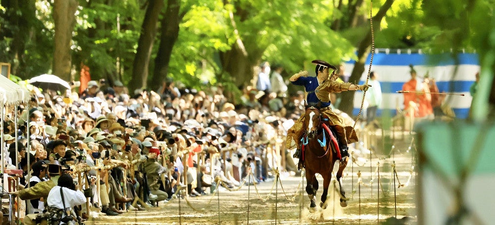 大勢の参拝者を背に、疾走する馬から矢を放つ射手（左京区で）＝川崎公太撮影