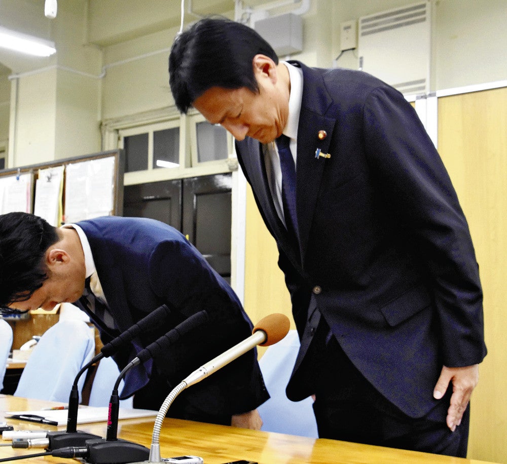 記者会見で頭を下げる武井氏（右）