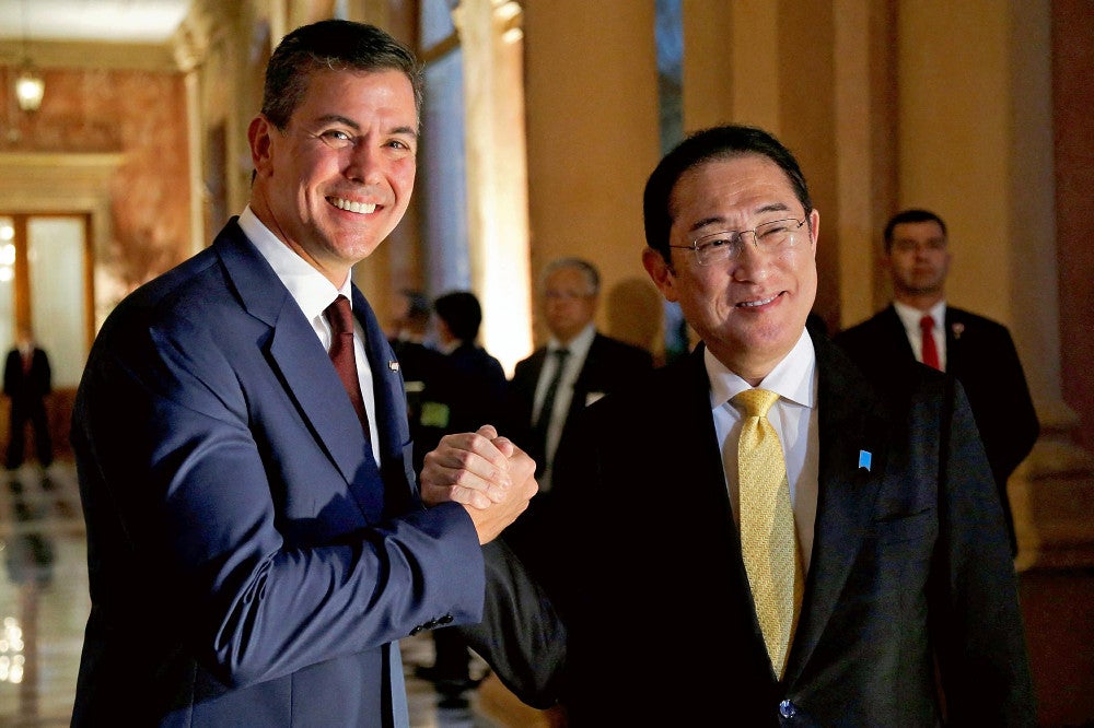 ３日、パラグアイの首都アスンシオンで、サンティアゴ・ペニャ大統領と握手する岸田首相（右）＝ロイター