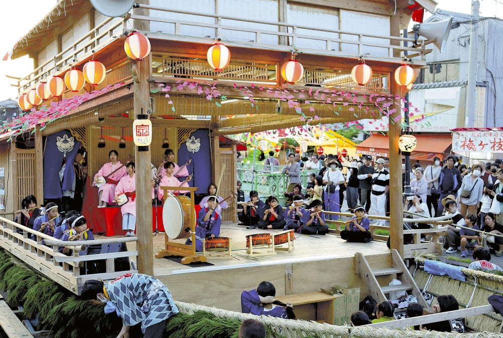掘割に浮かんだ舟舞台でお囃子を演奏する子どもたち