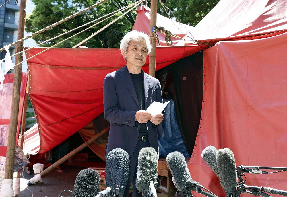 「紅テント」前で唐十郎さんへの思いを語る久保井研さん（５日午前、東京都新宿区の花園神社で）＝後藤嘉信撮影