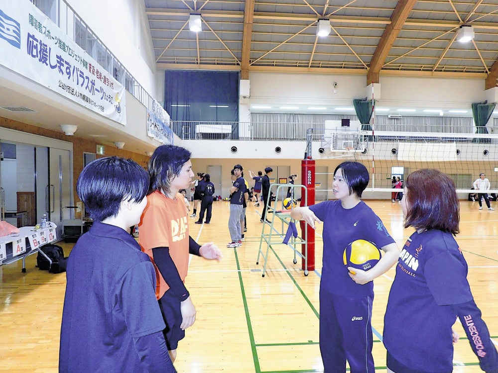 「ユニバーサルスポーツを広めたい」と願う清水さん（右から２人目）。聴覚障害者と健聴者が交流するバレーボール大会では身ぶりを交えて作戦を練った（神戸市西区で）