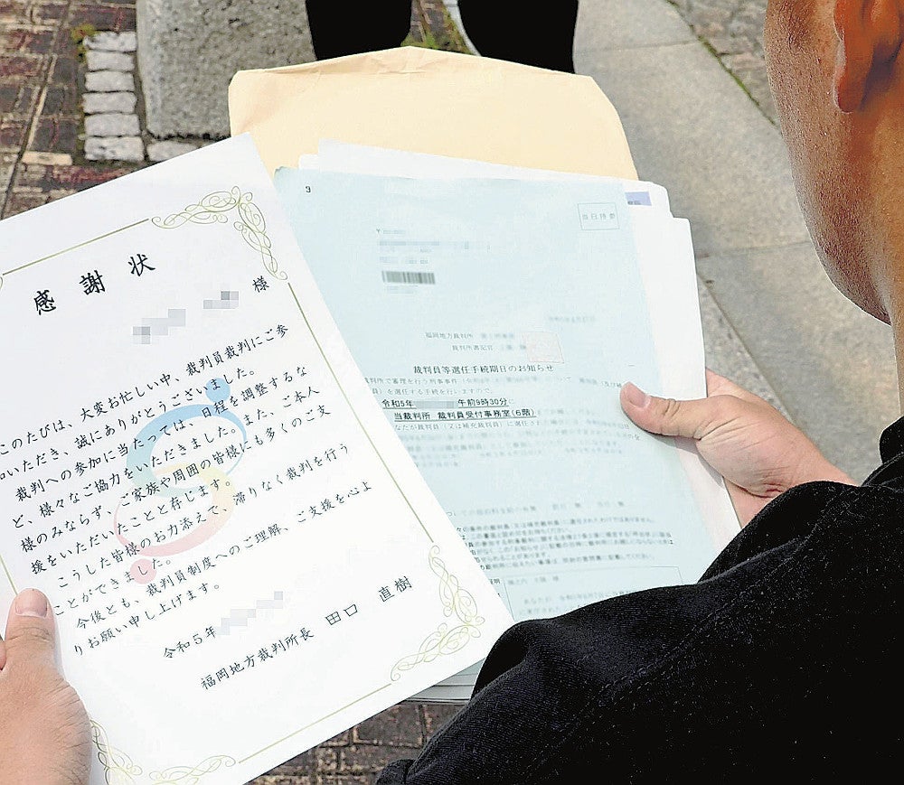 裁判員として参加したことへの感謝状などを手にする大学生（４月１７日、福岡県内で）＝画像の一部を修整しています