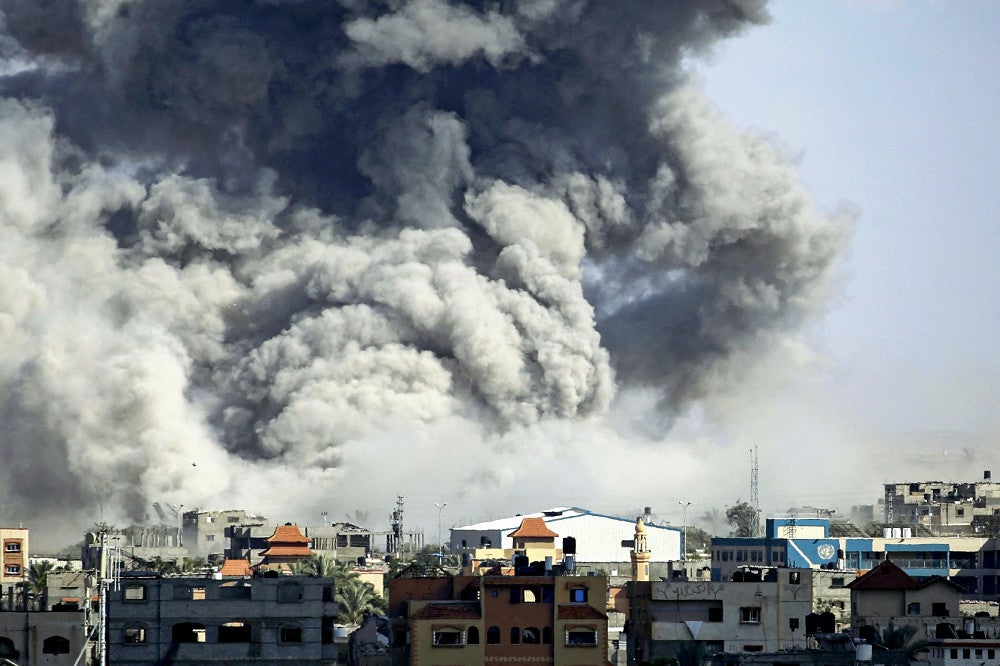６日、ガザ南部ラファで、イスラエル軍の攻撃を受けて立ち上る煙＝ＡＦＰ時事