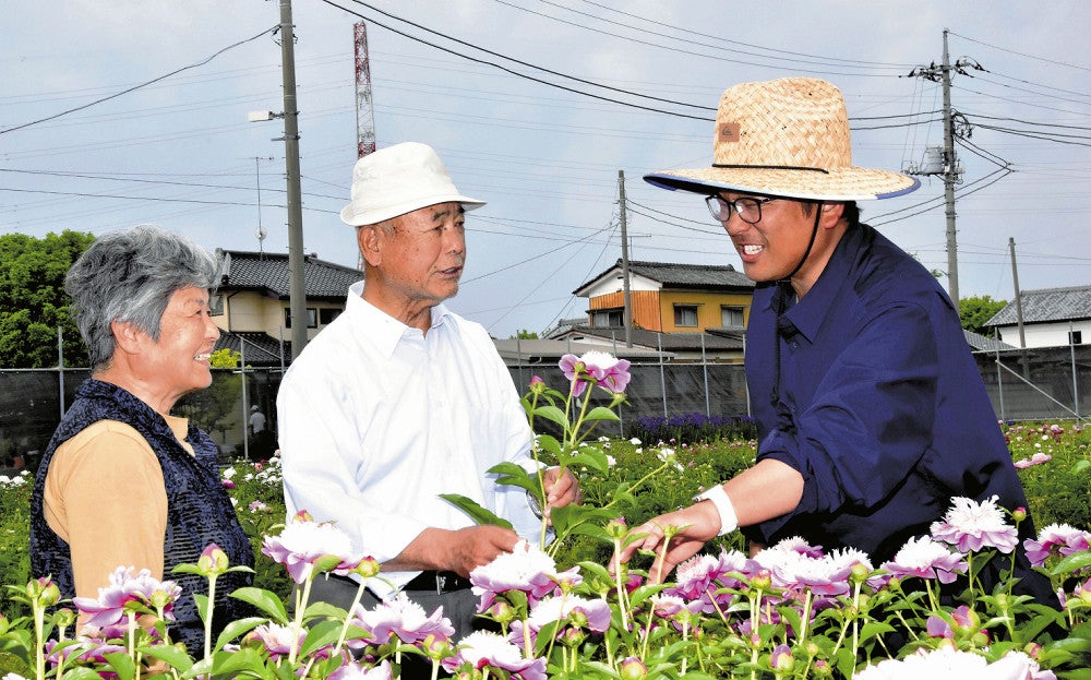 来園者にシャクヤクの花について説明する片岡さん（右端）（足利市里矢場町で）