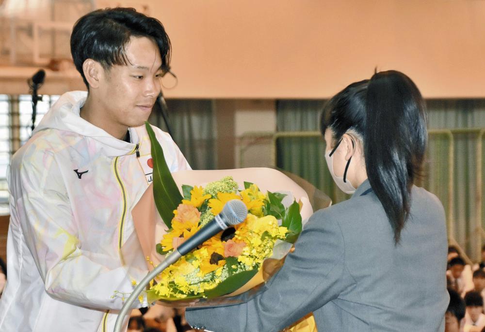 在校生から花束を贈られる荻原選手（左）