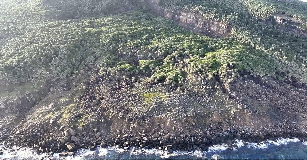ドローンで撮影した尖閣諸島・魚釣島の北側。植物のない岩肌が目立っている（沖縄県石垣市提供）