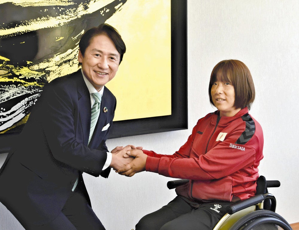 武内市長（左）と握手を交わし、パリ大会での活躍を誓う重定選手
