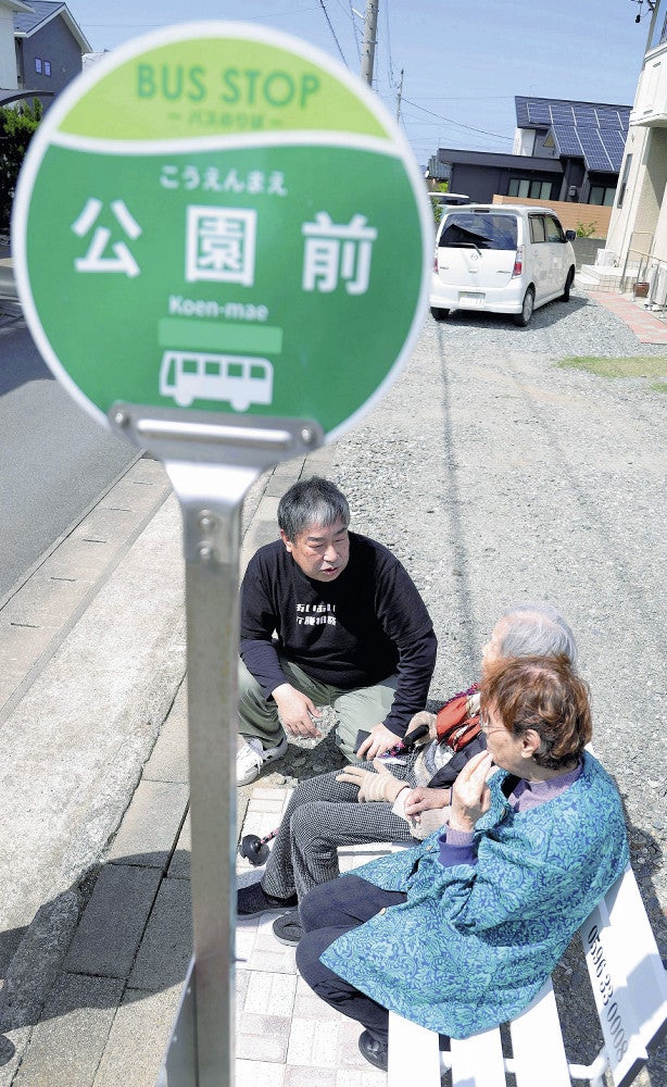 「バス停」を訪れた高齢者と話す中村さん（上）（４月、明和町で）＝松岡樹撮影